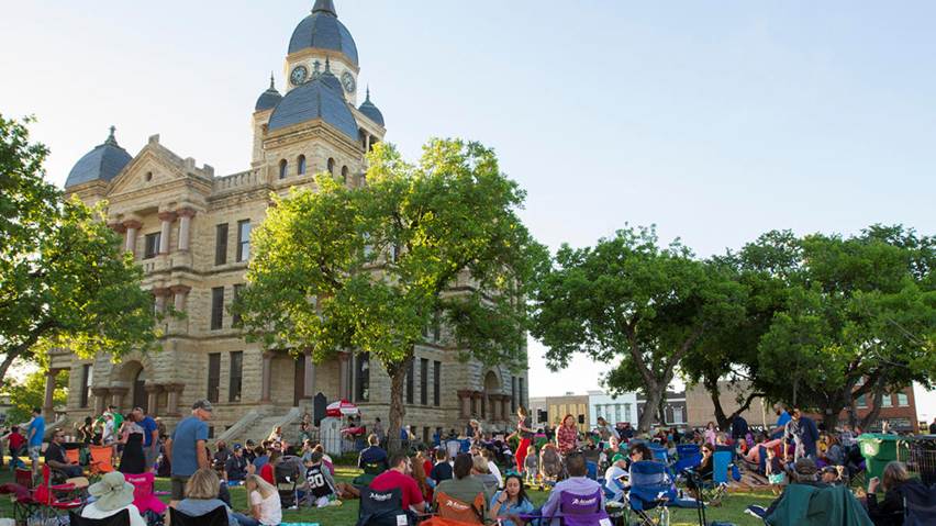 Summer activity in Denton. Historic Denton County Courthouse lawn with residents. 